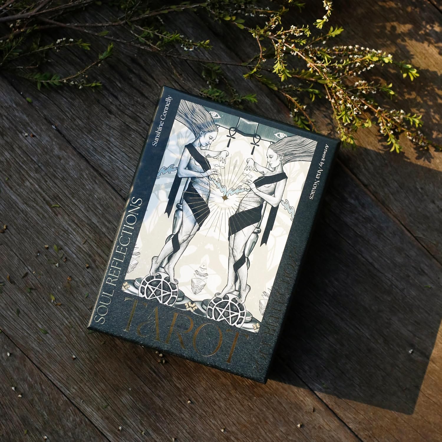 Tarot card box with artwork on a wooden surface
