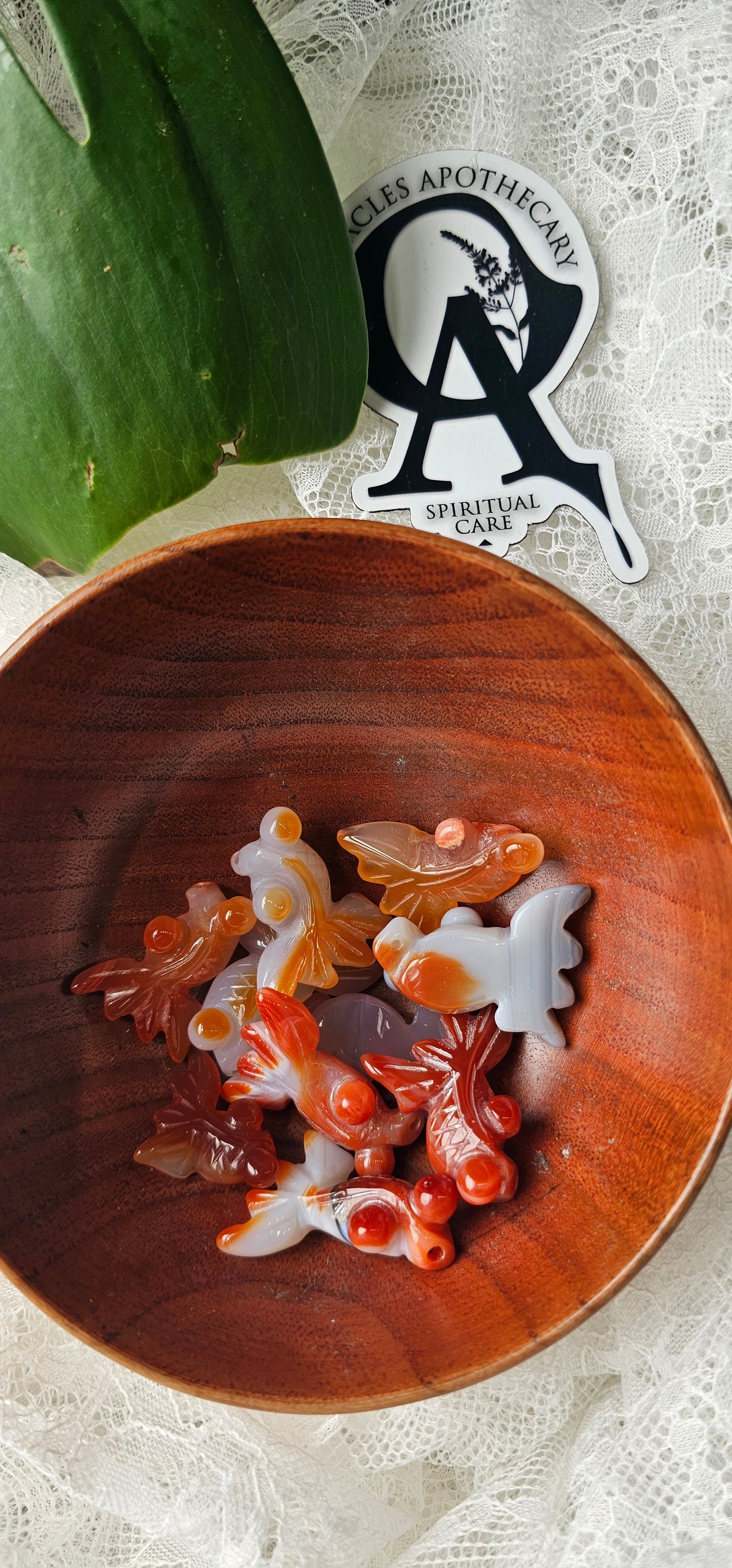 Wooden bowl with decorative items on a textured surface, featuring a logo in the corner.