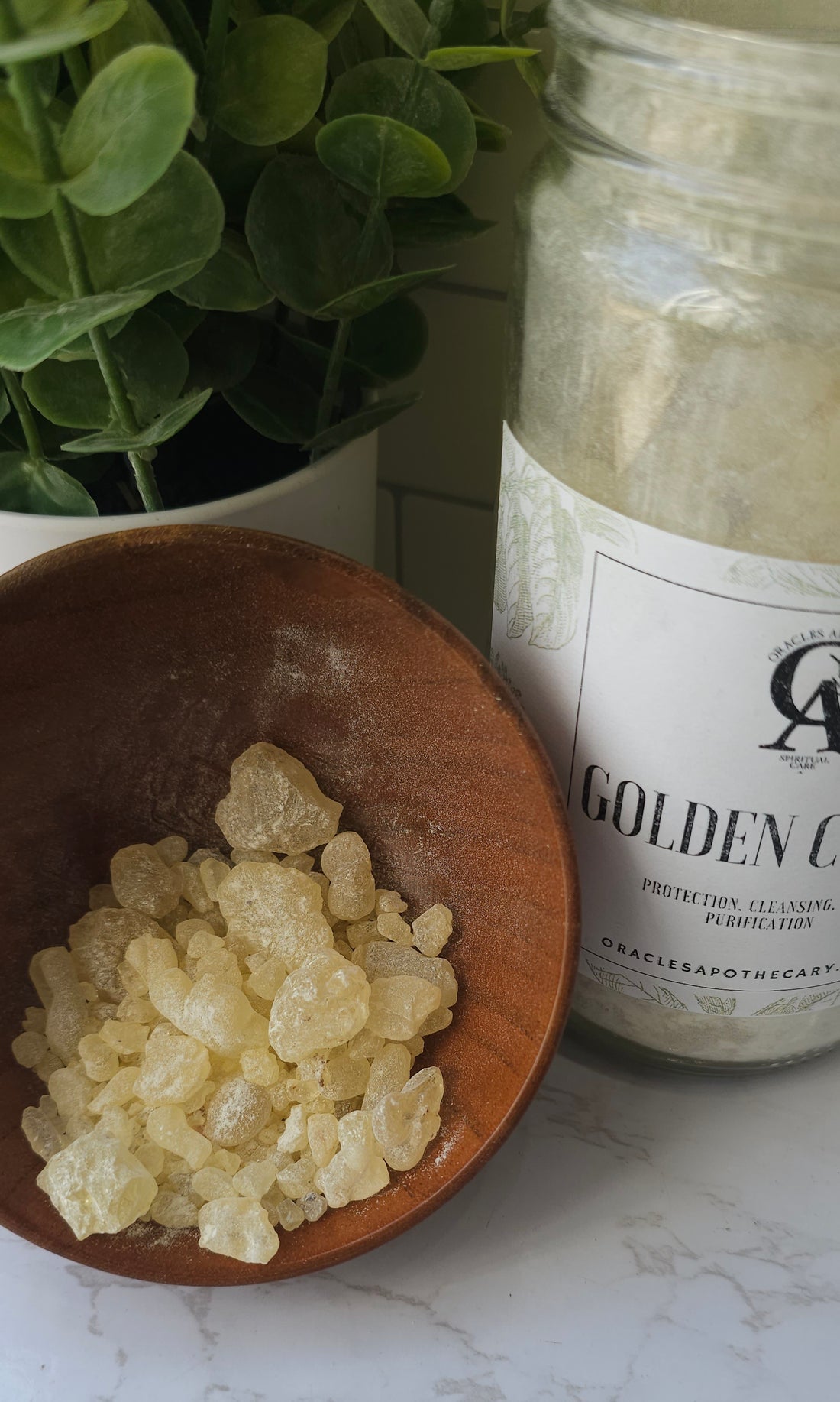 Golden Copal in a wooden bowl next to a glass jar of Golden Copal