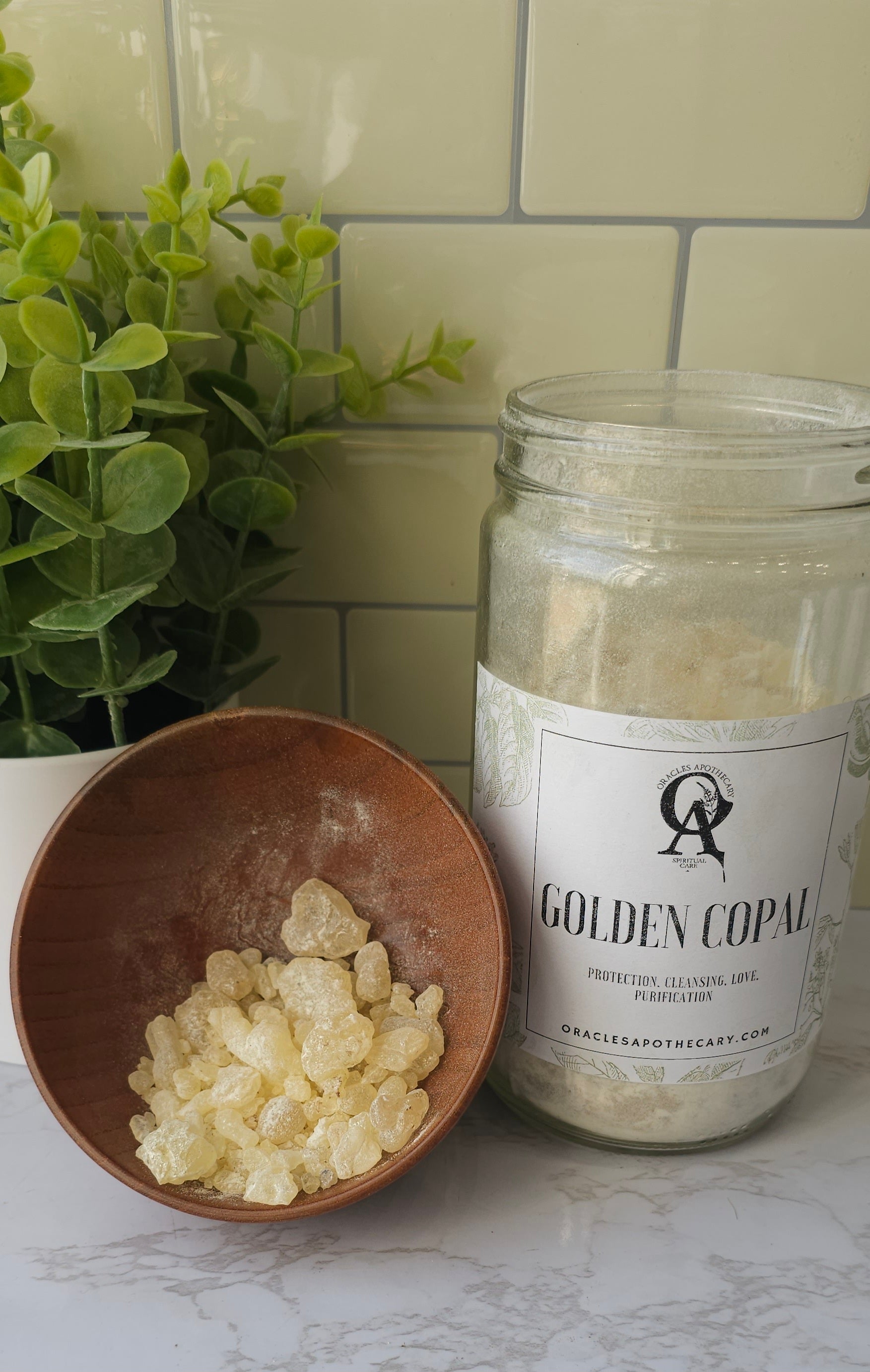 Golden Copal pile in a wooden bowl next to a glass jar of Golden Copal
