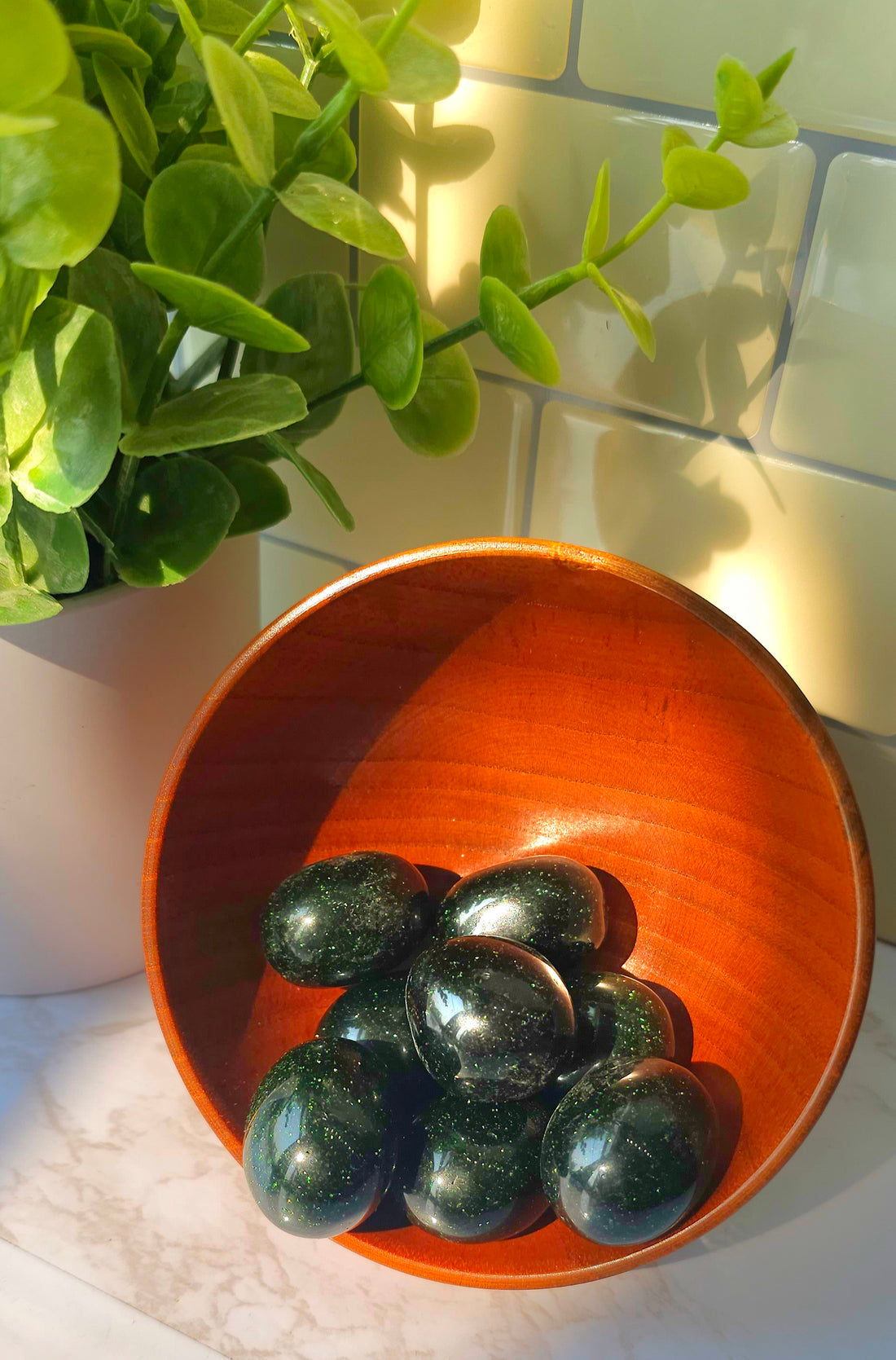 Green Goldstone crystals stones in a wooden bowl