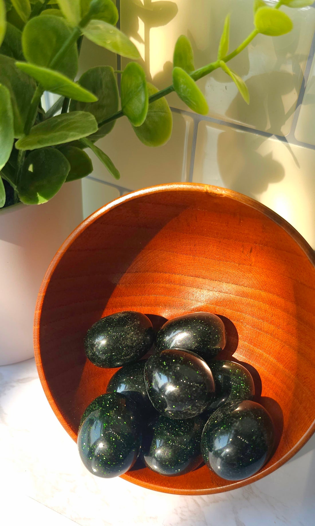 Green Goldstone crystals stones in a wooden bowl