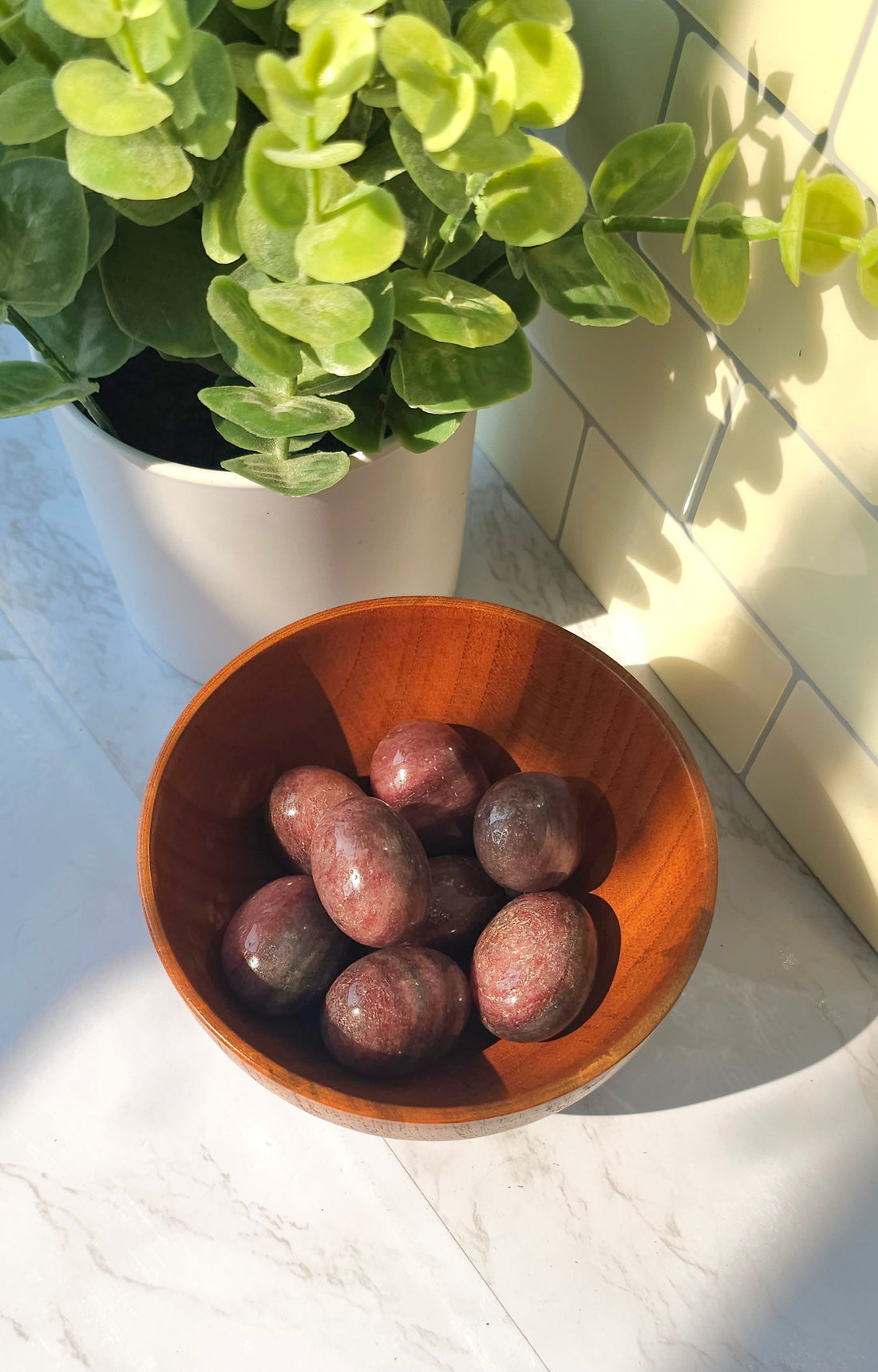 Strawberry Quartz crystals stones in a wooden bowl
