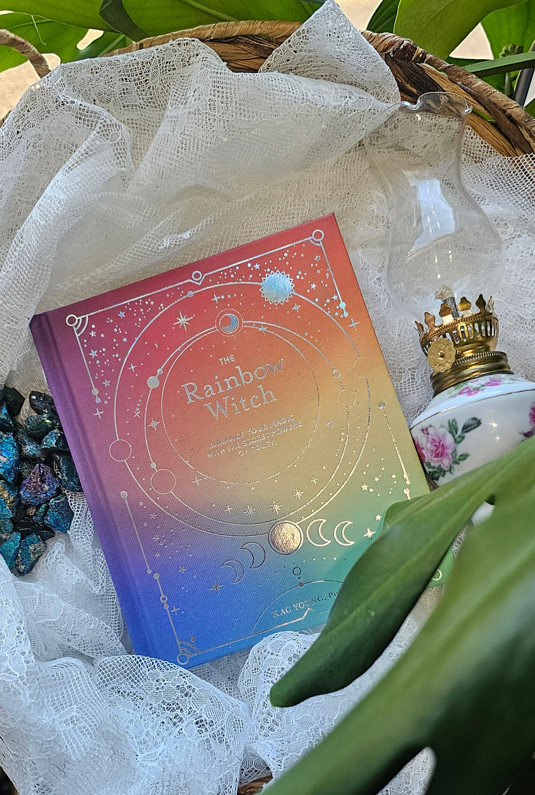 The Rainbow Witch sitting on a wooden basket