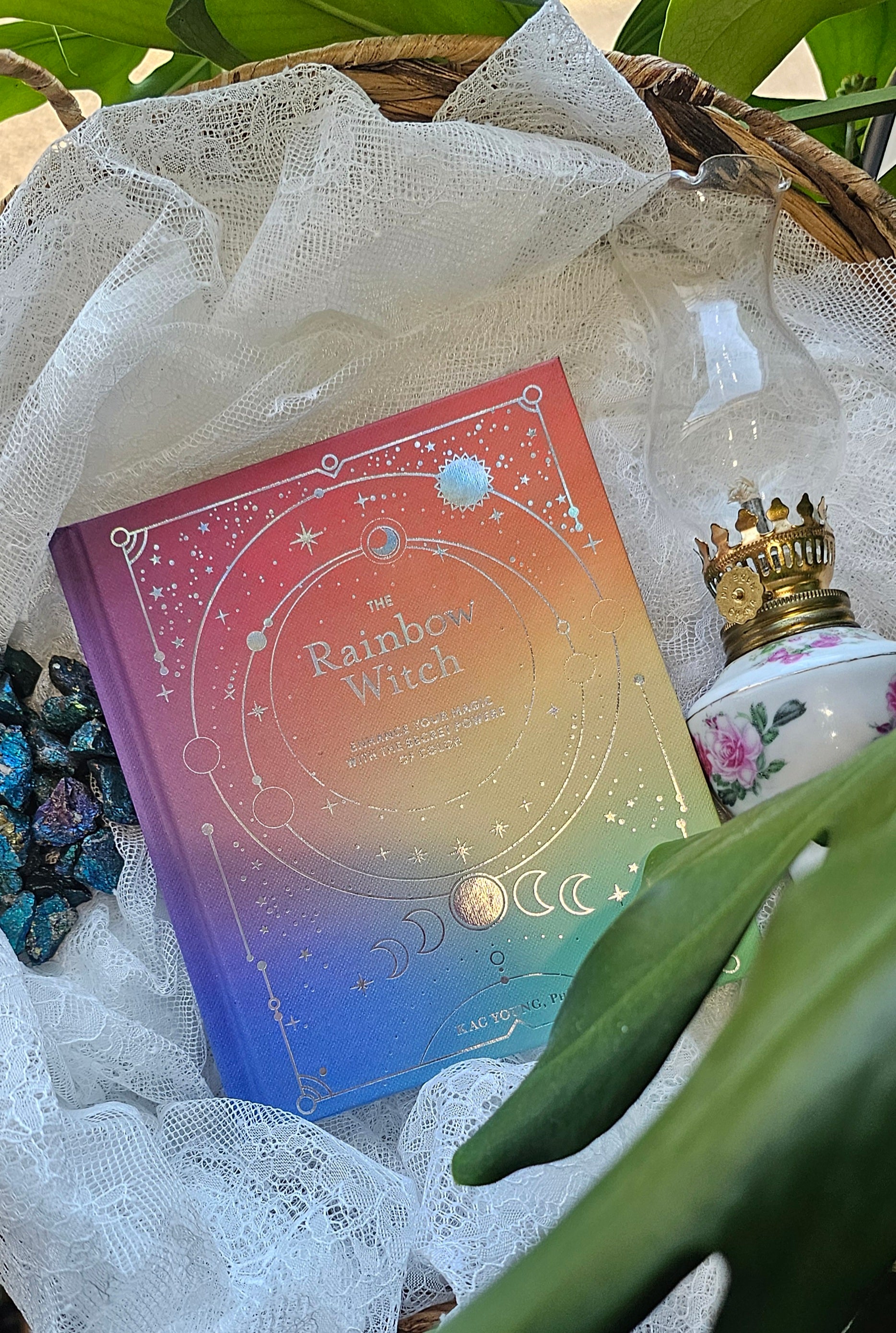 The Rainbow Witch sitting on a wooden basket