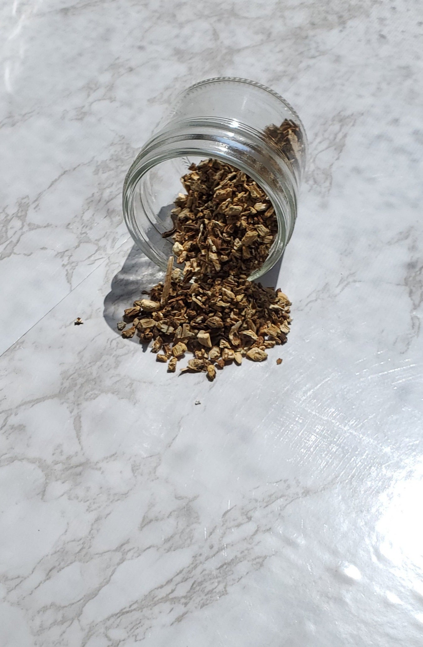 Angelica Root spilling out of a glass jar