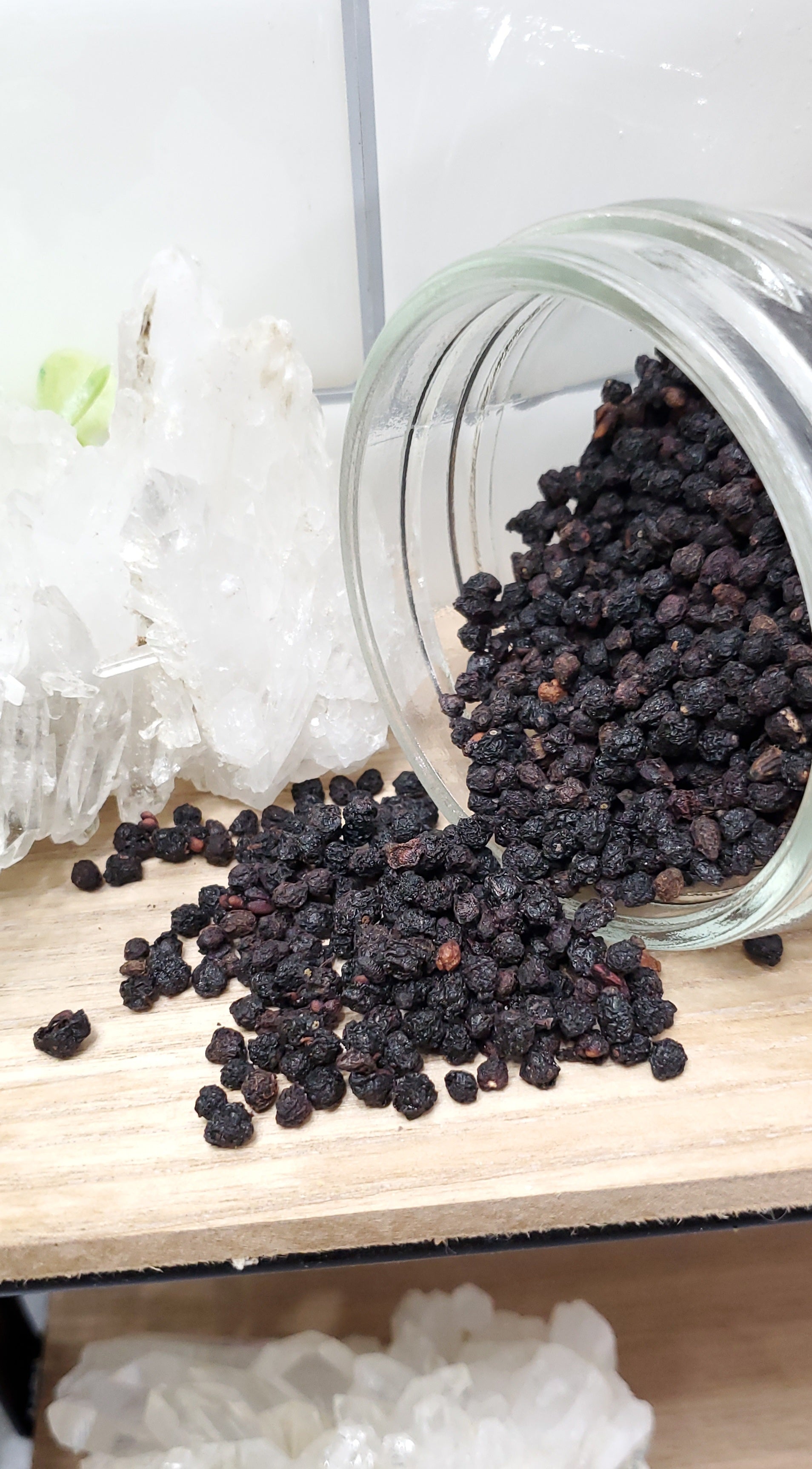 Elderberries spilling out of glass jar