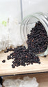 Elderberries spilling out of glass jar