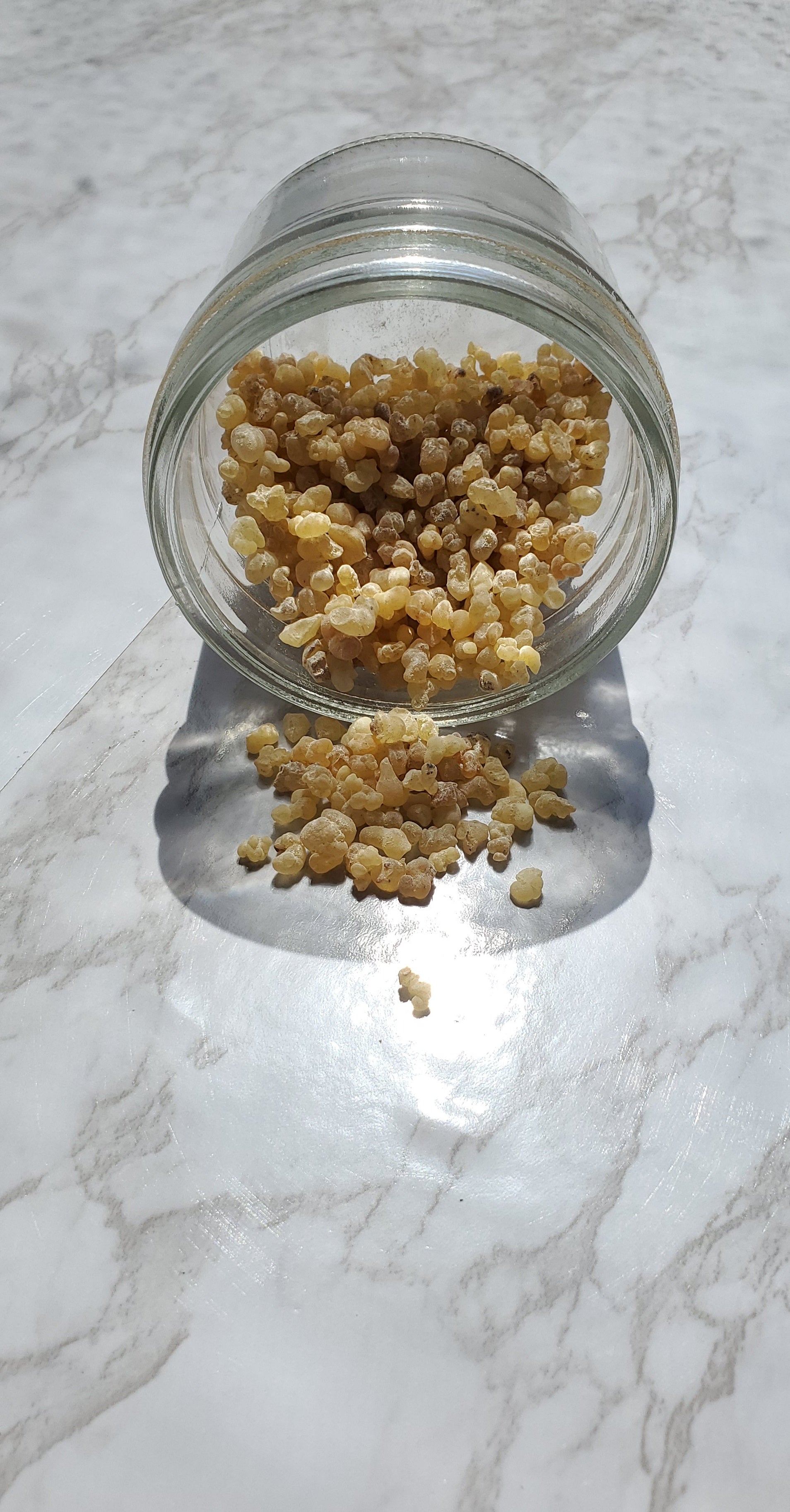 Frankincense Tears spilling from a glass jar