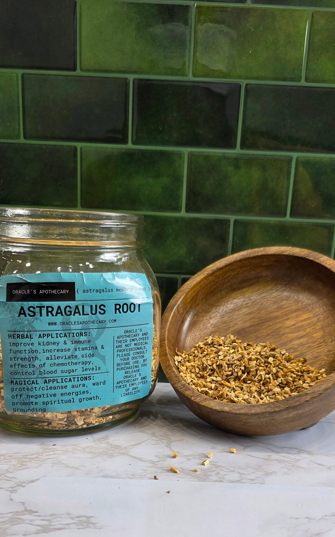  Astragalus Root in clear jar with label and in wood bowl on a marble counter top with green tile background 