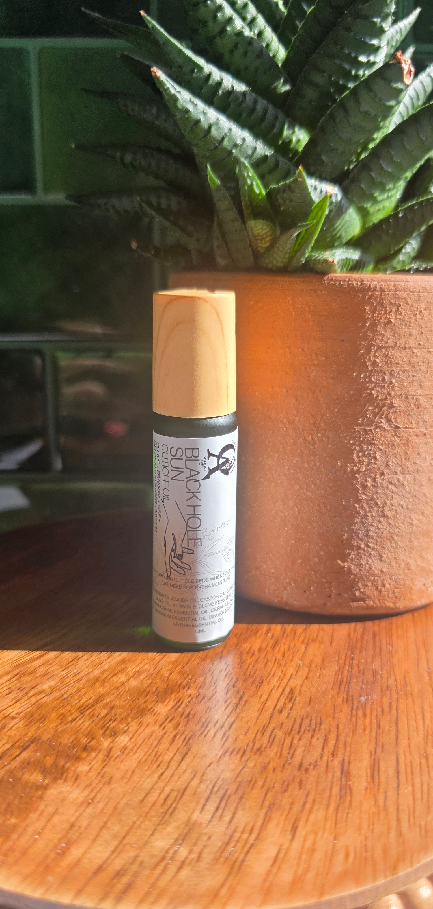 Skincare serum bottle on a wooden surface with a plant in the background