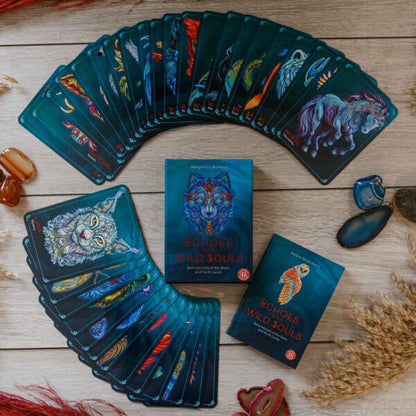 spread of all the cards of the deck, guidebook, and card box on a wood table