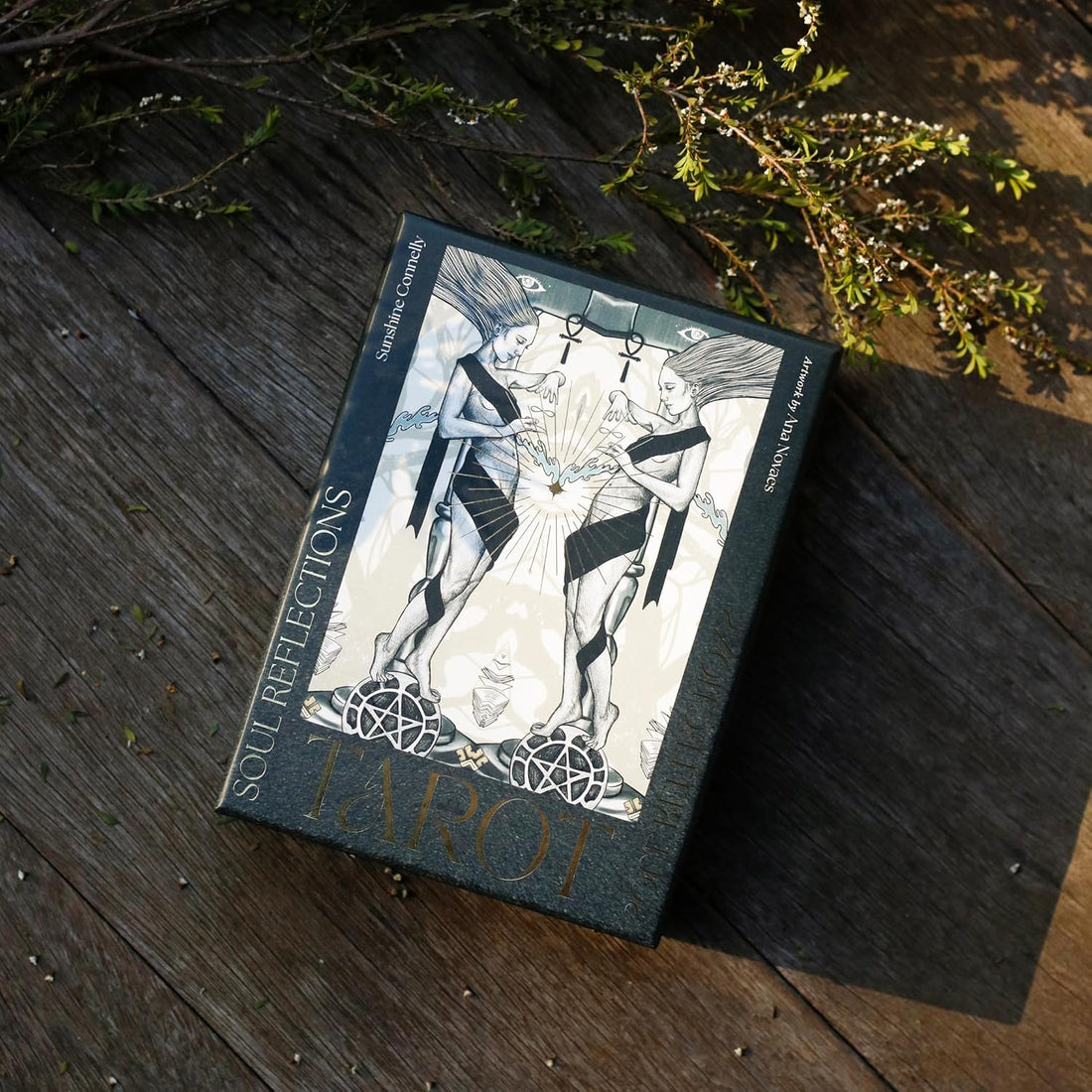 Tarot card box with artwork on a wooden surface