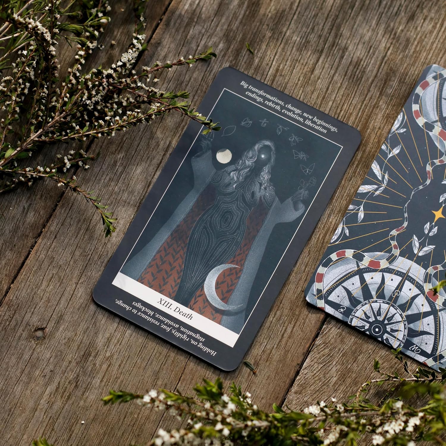 Tarot card with a wolf design on a wooden surface with flowers
