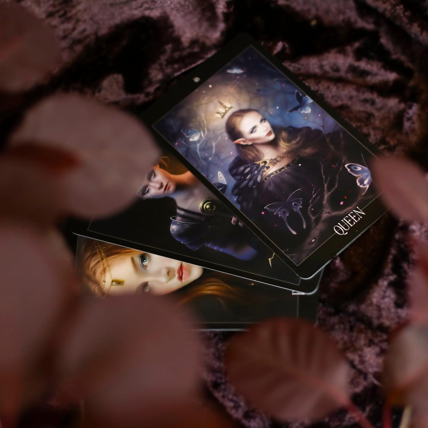 three cards spread on top of each other with the queen on top