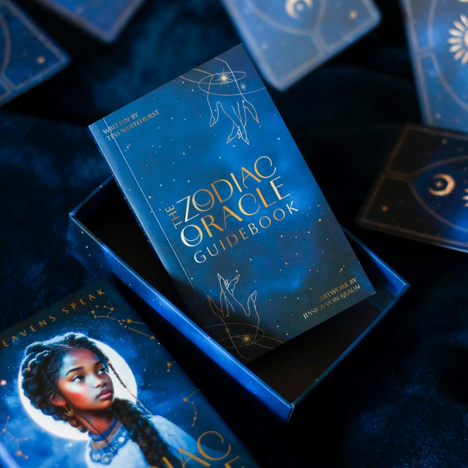 Zodiac Oracle Guidebook with tarot cards on a dark background