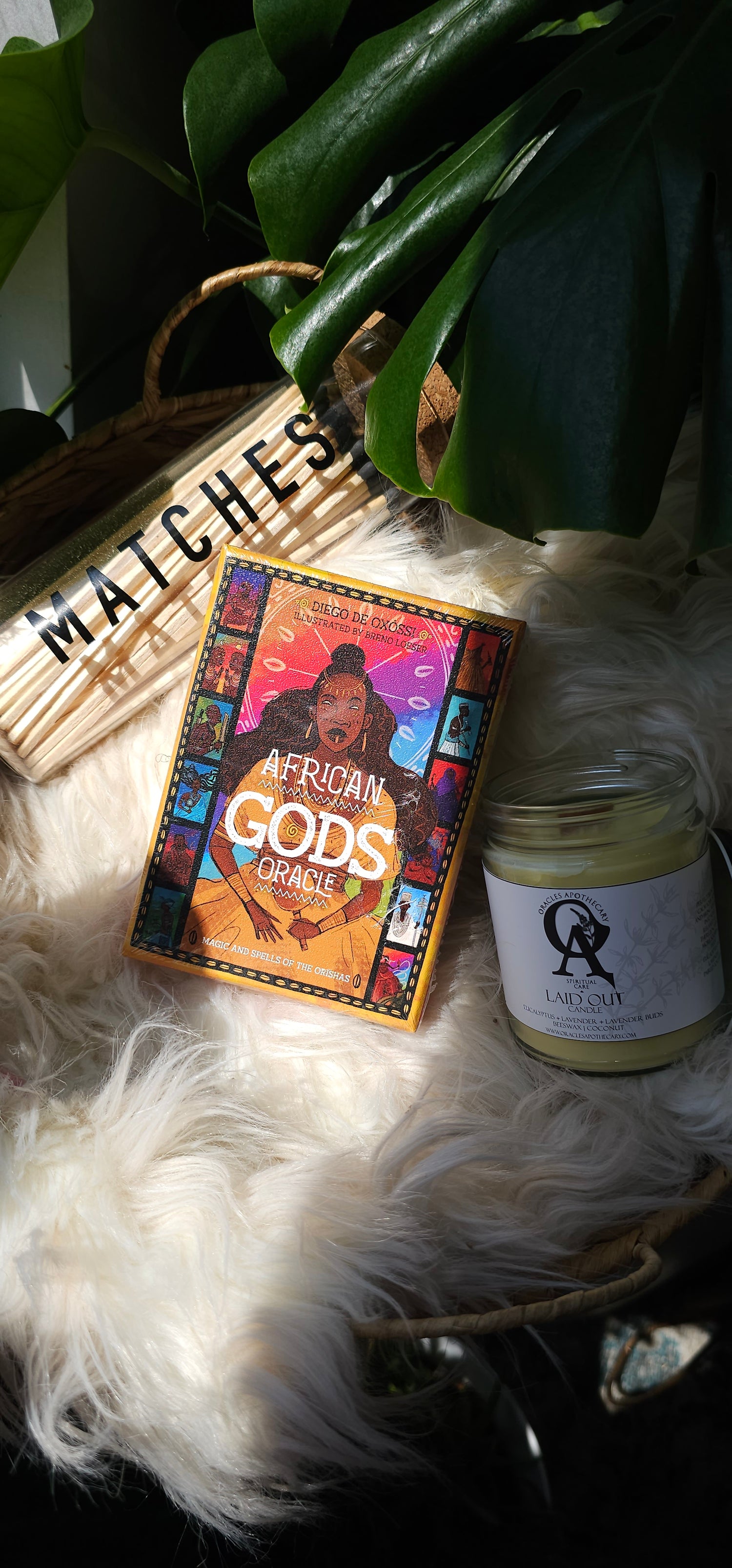 African Gods Oracle deck sitting next to matches and an oracles apothecary candle