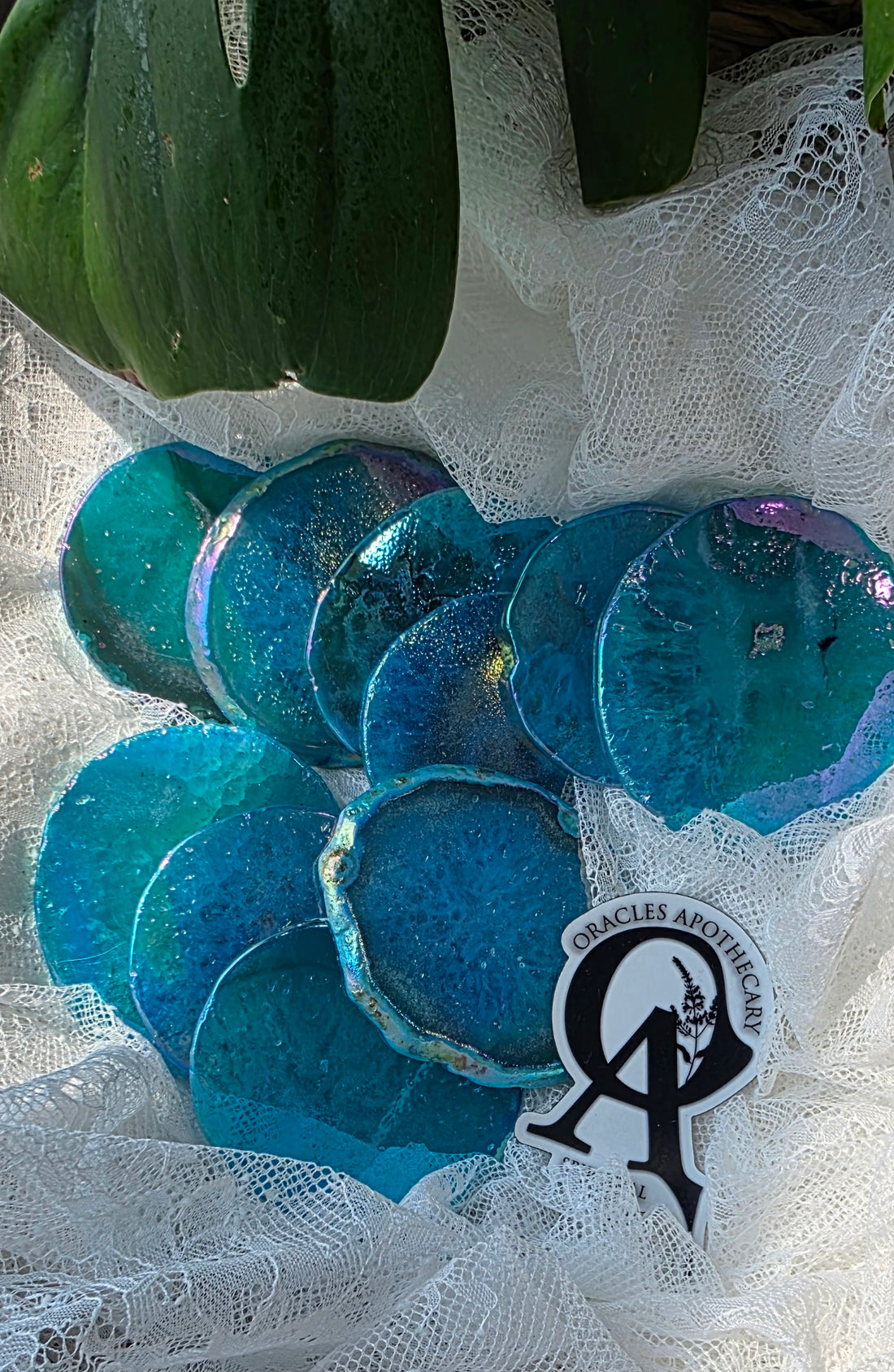 Blue glass discs on a white lace background with a visible brand logo.