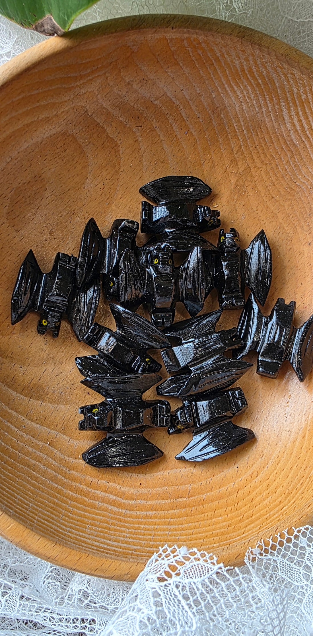 Collection of black stones on a wooden surface with a white lace doily underneath.