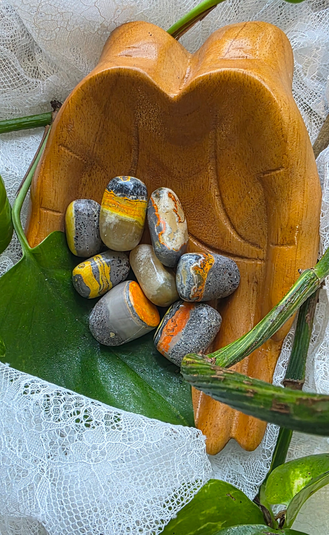 Wooden bowl with stones on a lace and leaf background