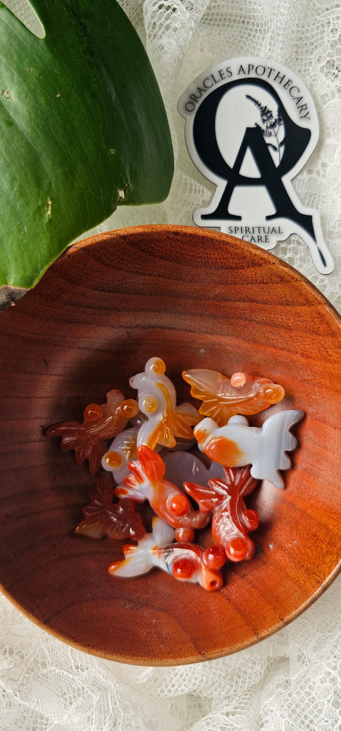Wooden bowl with decorative soap pieces on a textured surface, featuring a logo in the corner.