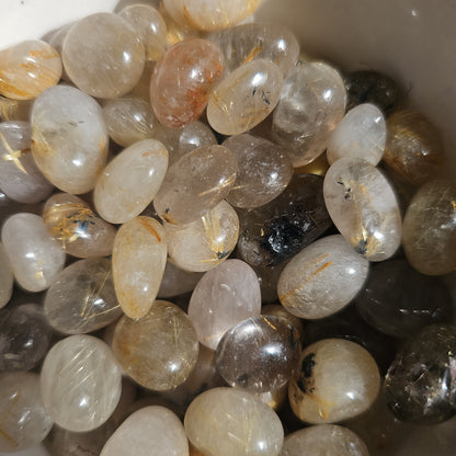 Golden Rutile crystals stones in a wooden bowl