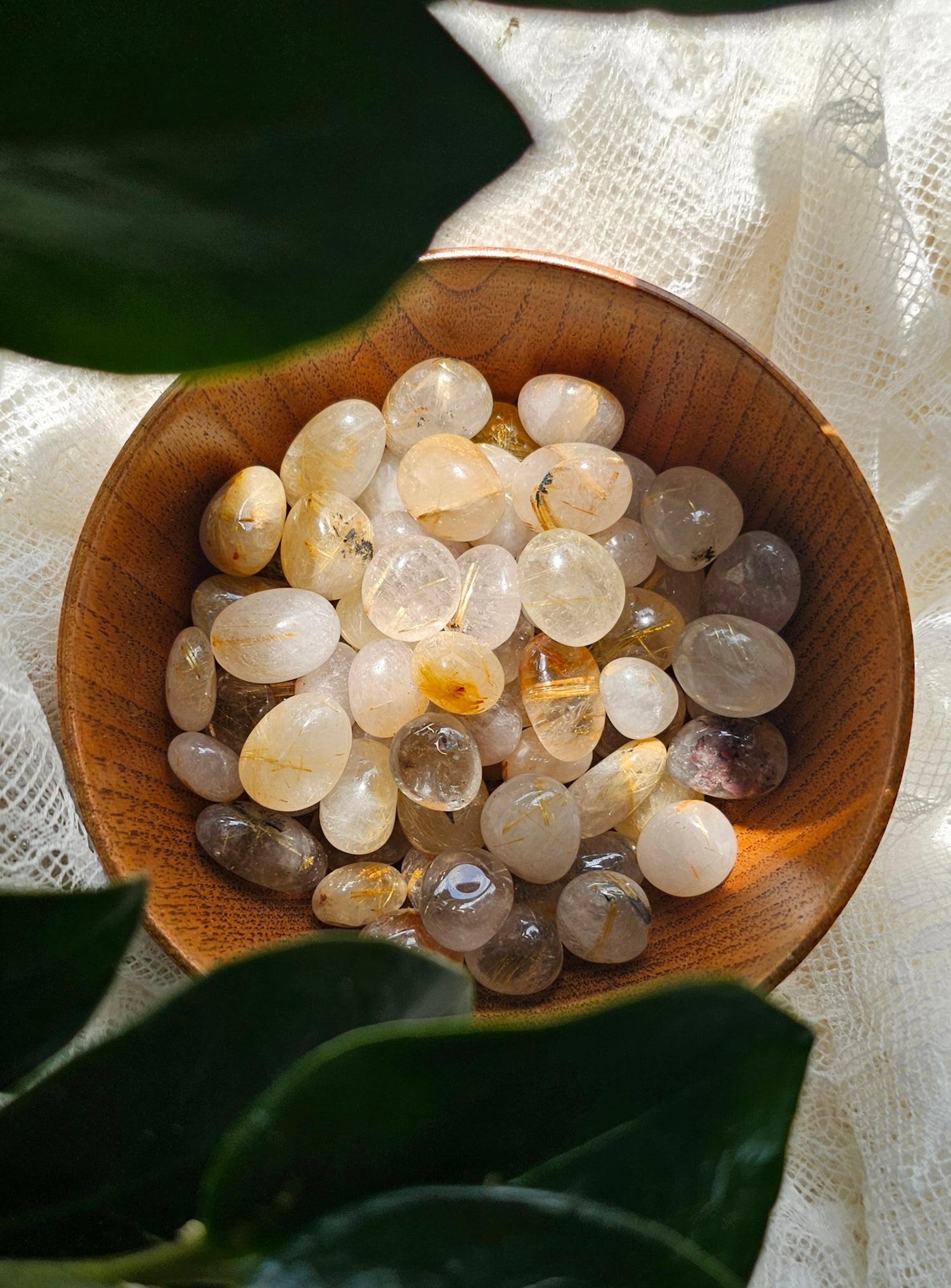 Golden Rutile crystals stones in a wooden bowl