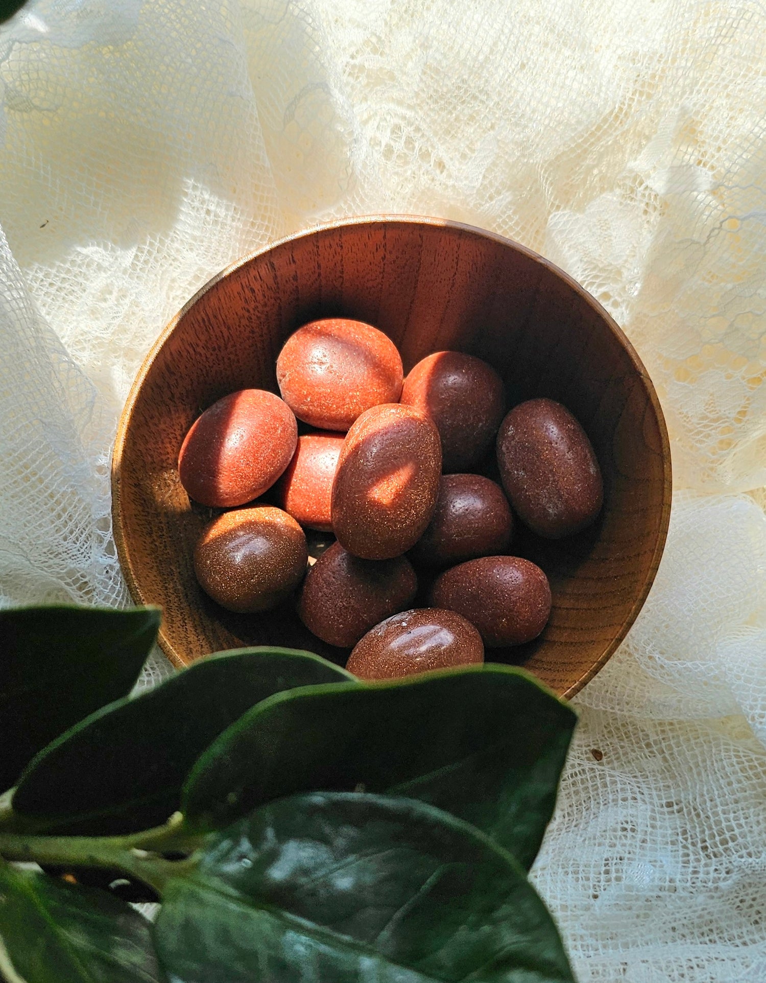 Goldstone piled up in a wooden bowl