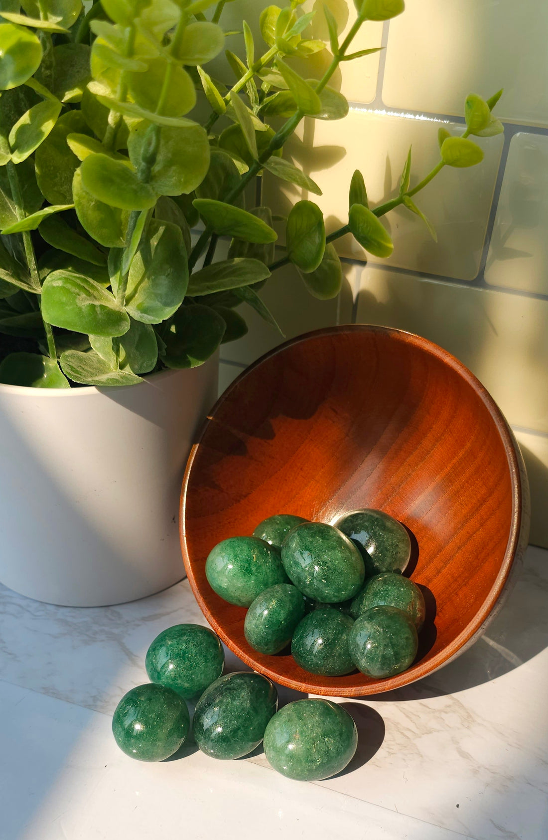 Green Strawberry Quartz piled in a wooden bowl