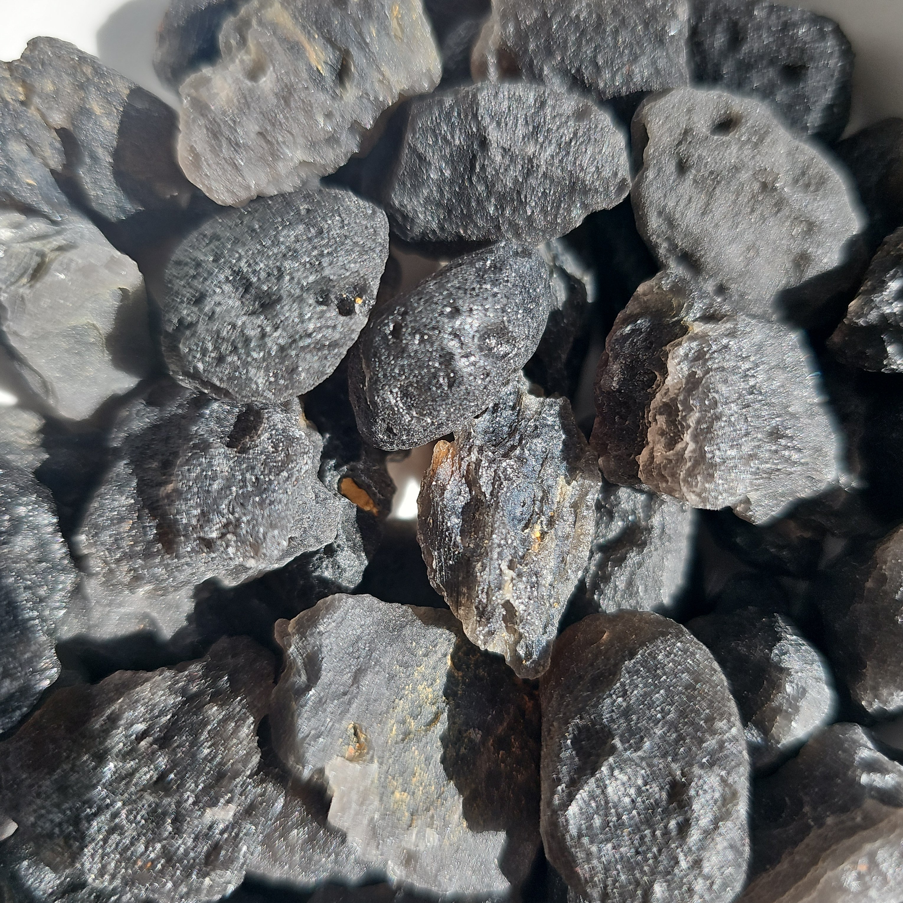 Ivory Coast Tektite crystals stones piled in a bowl