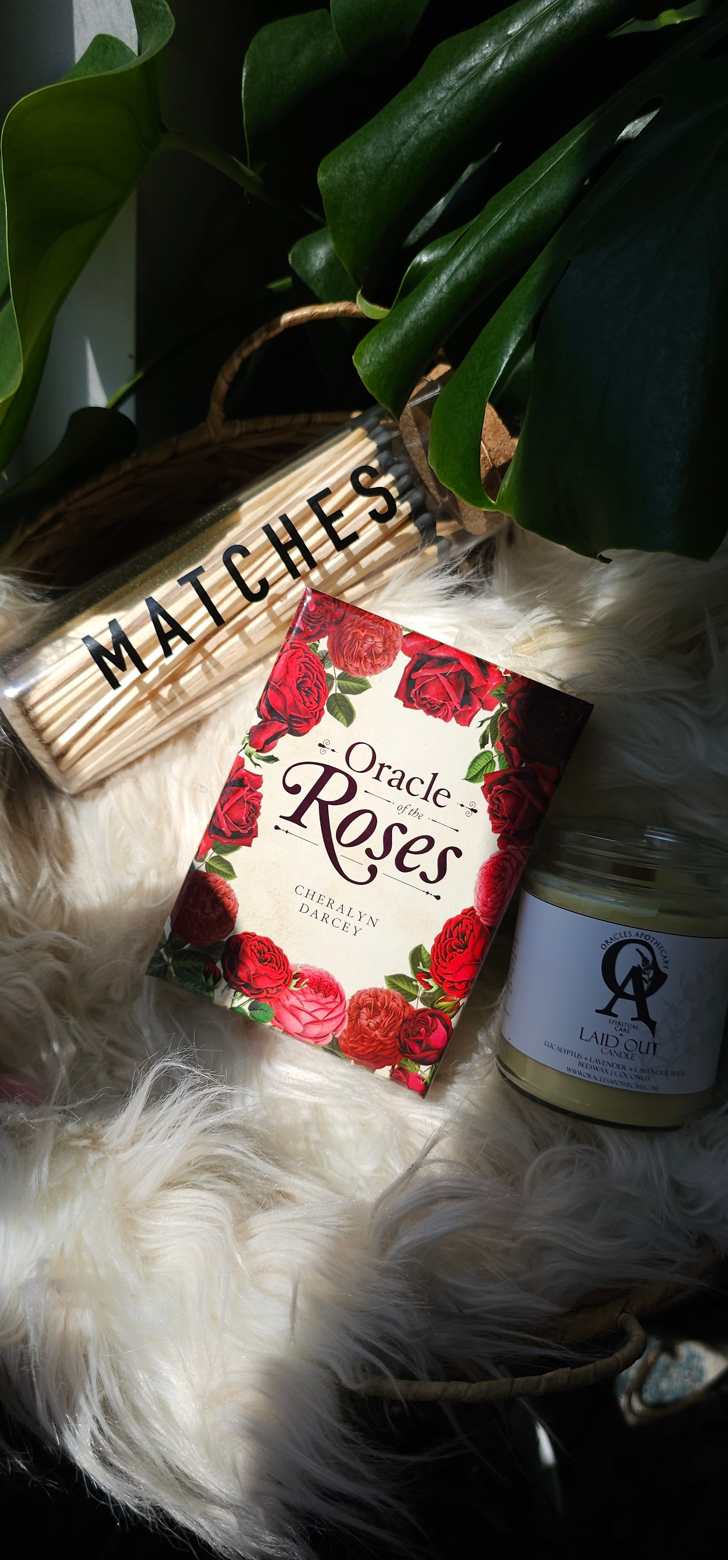 Oracle of the Roses deck sitting next to matches and an oracles apothecary candle
