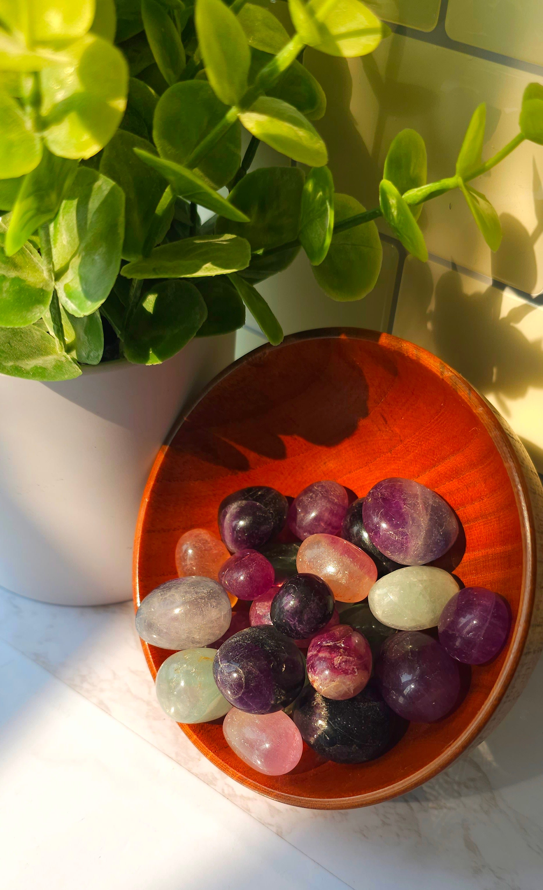 Rainbow Fluorite crystals stones in a wooden bowl