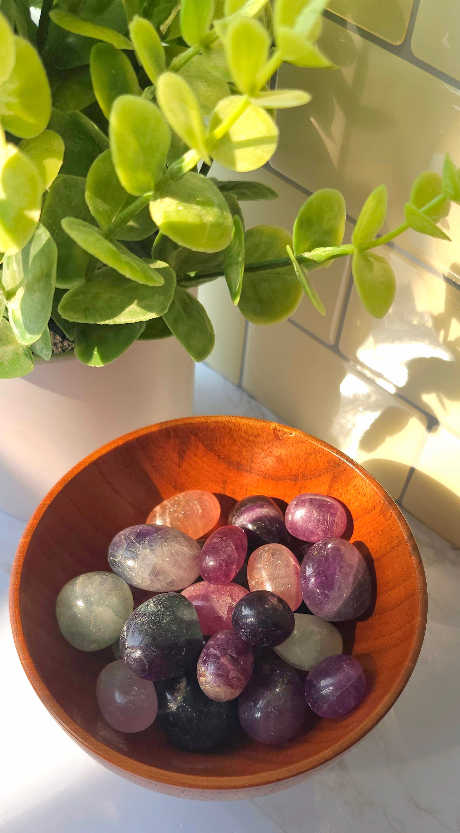 Rainbow Fluorite crystals stones in a wooden bowl