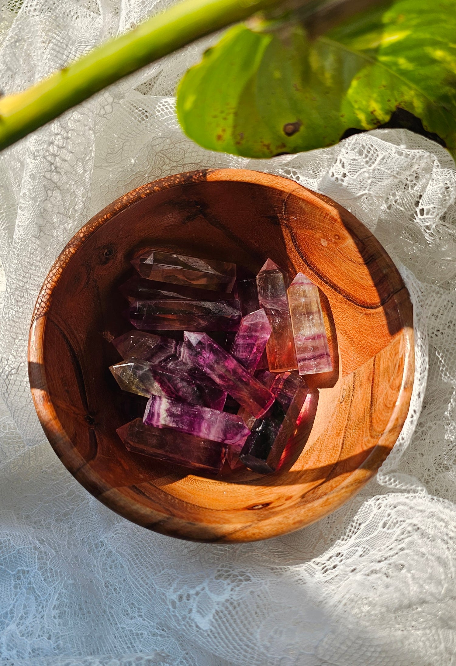 Rainbow Fluorite crystals stones piled in a wooden bowl