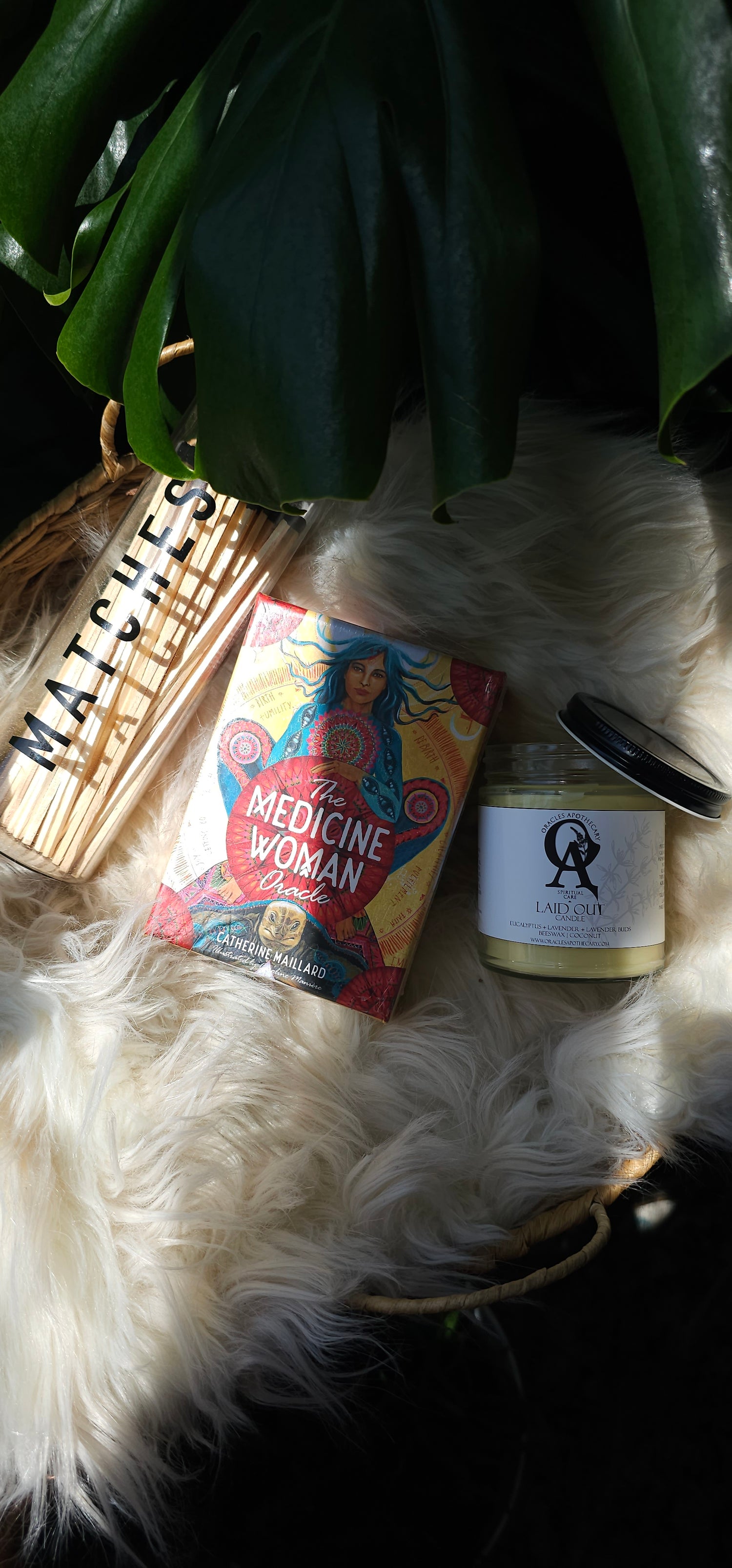 The Medicine Woman Oracle deck next to matches and an oracles apothecary candle