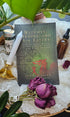 Witches, Druids, and Sin Eaters book lying next to tincture and roses