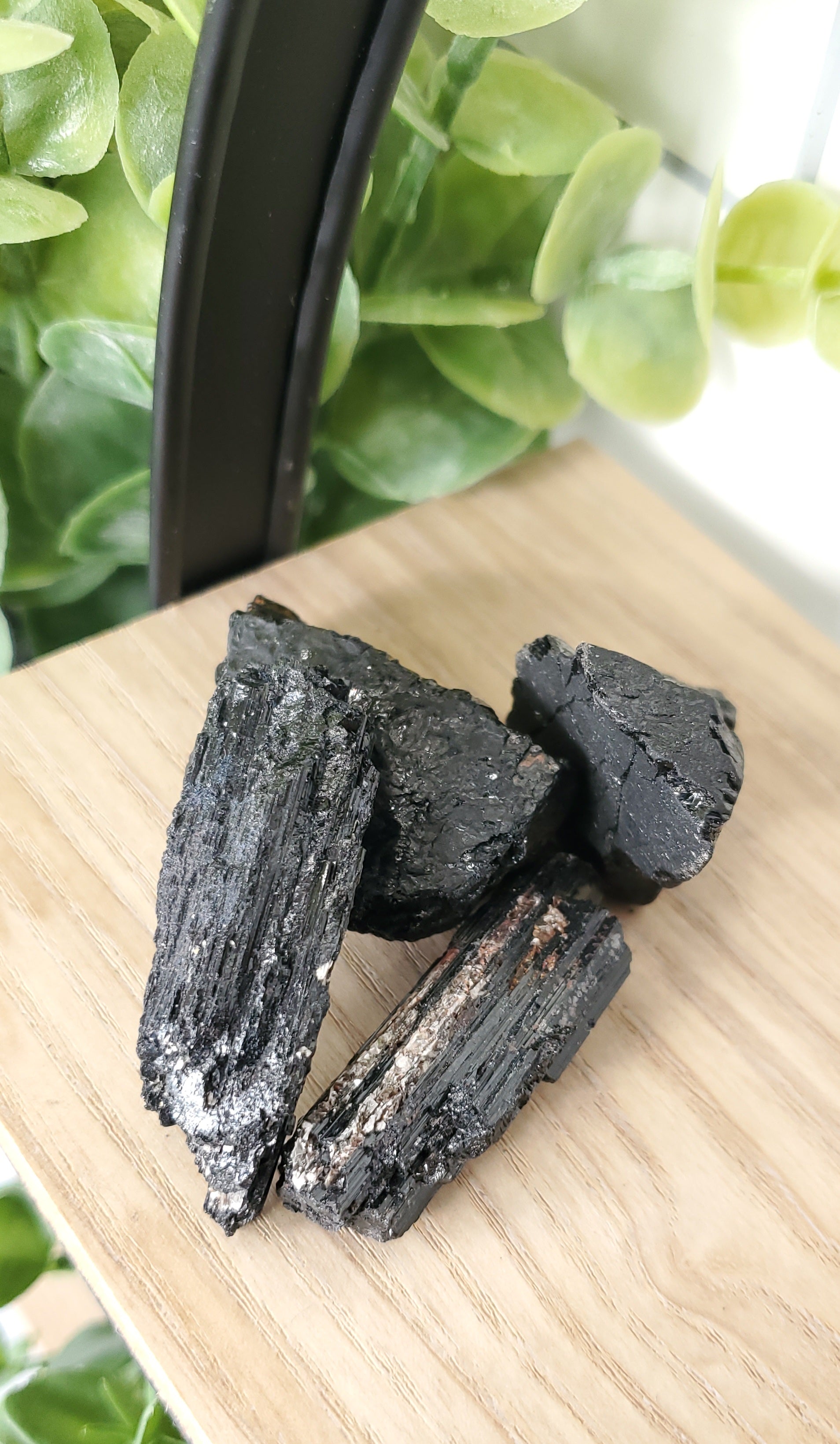 Black Tourmaline piled up on wooden shelf