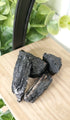 Black Tourmaline piled up on wooden shelf