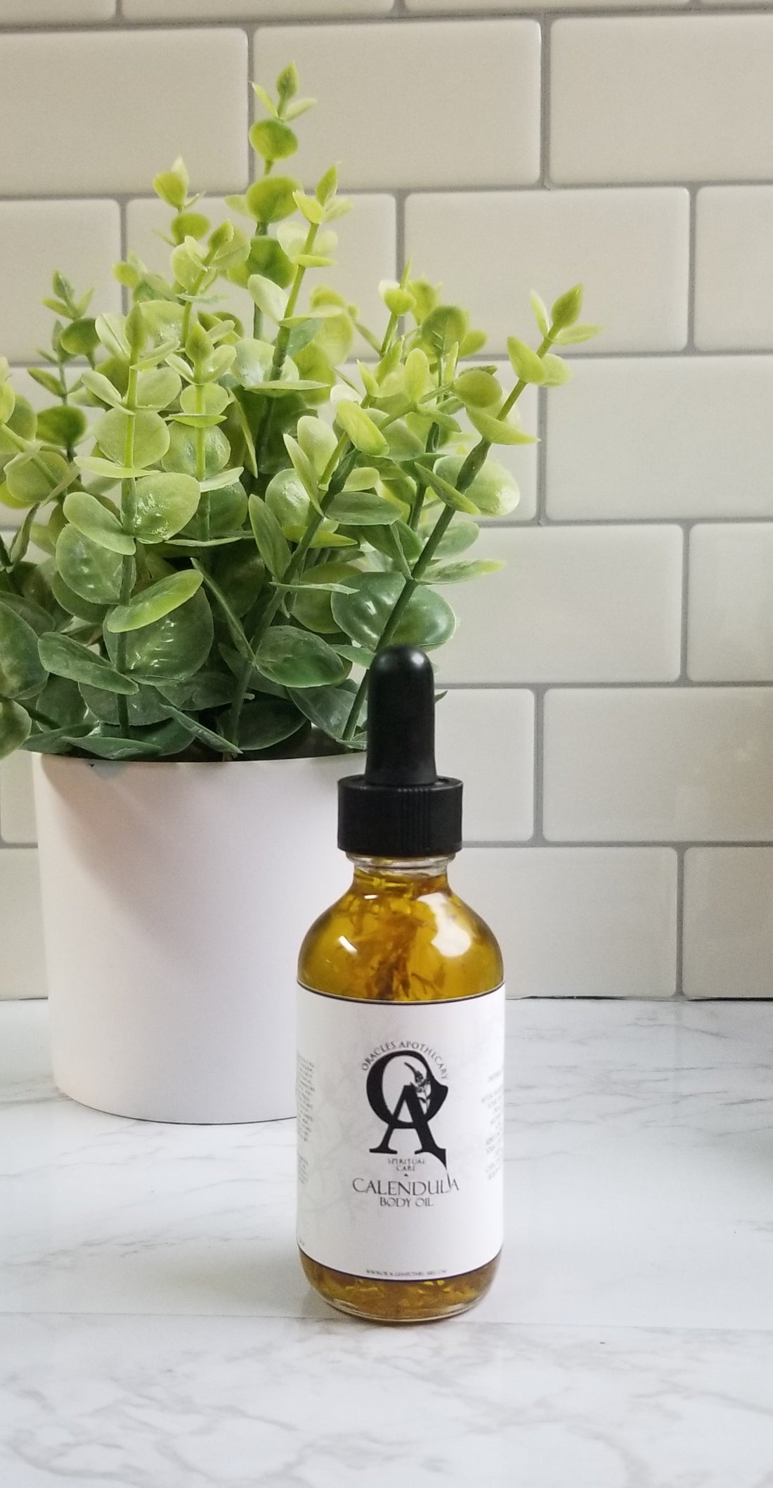 Calendula Oil tincture sitting on a white table