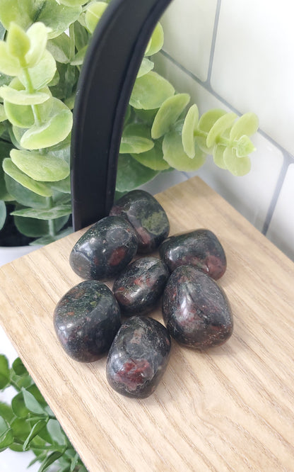 dragons blood crystals stones in a pile on a shelf