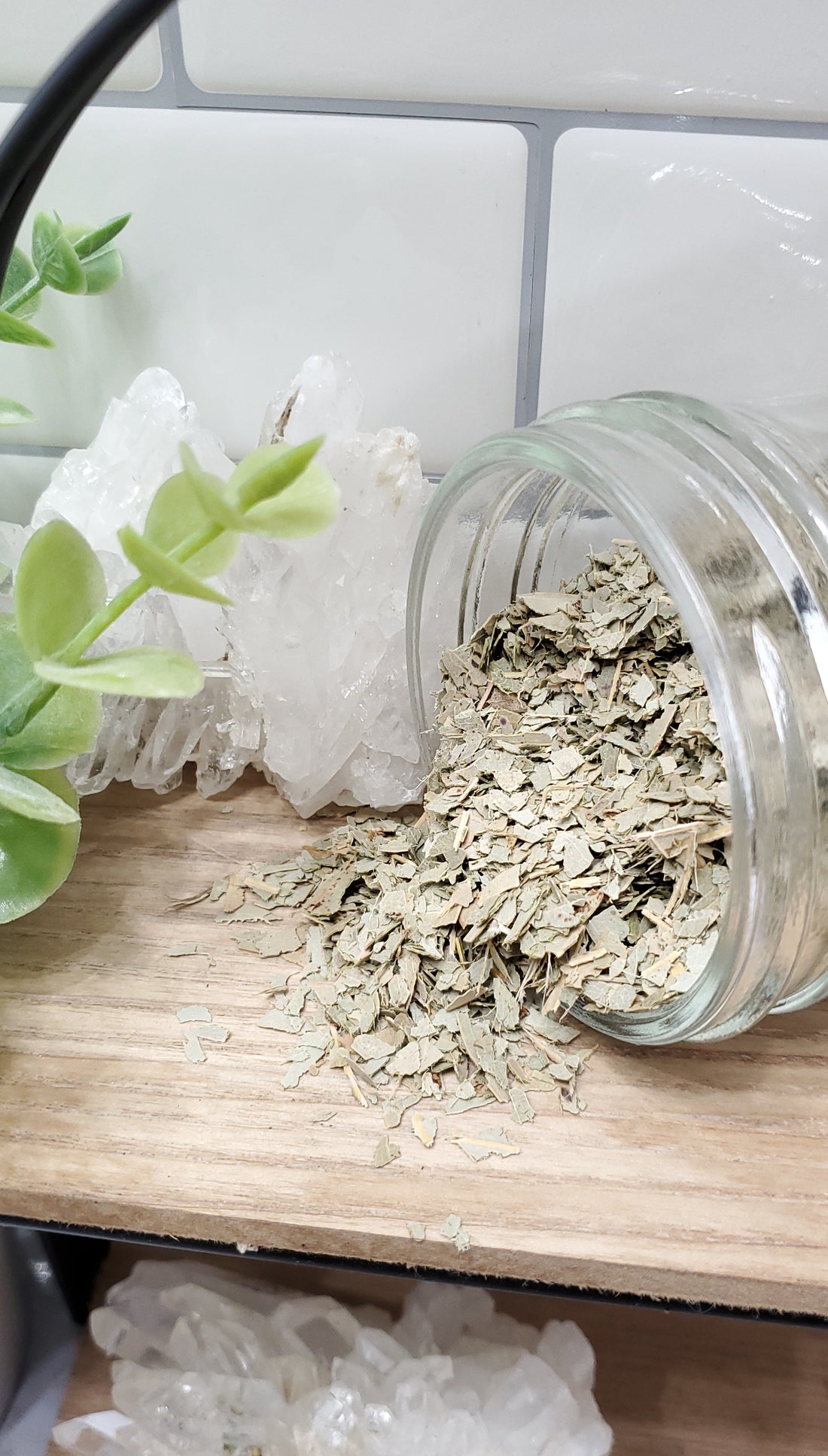 Eucalyptus spilling from glass jar on shelf