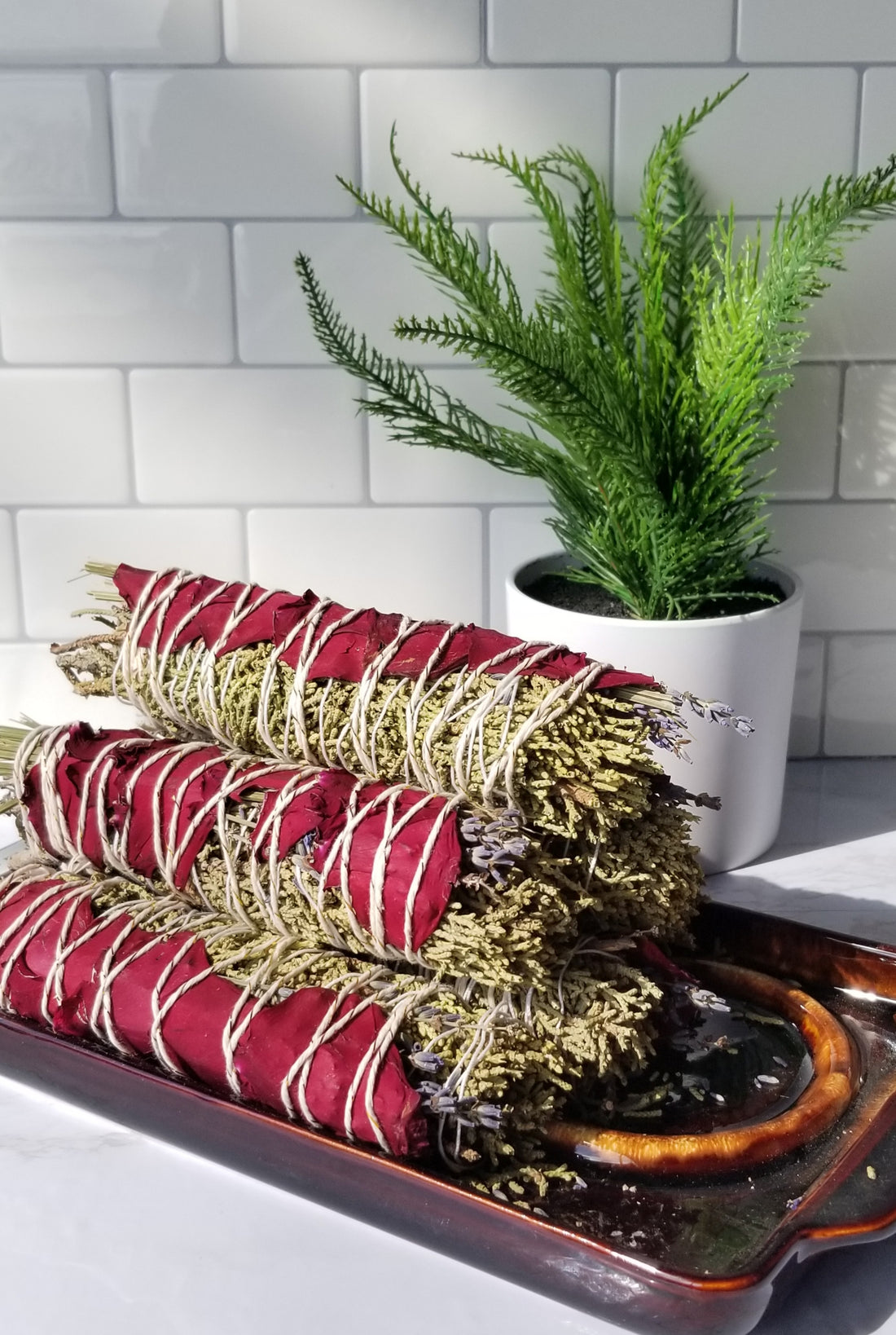 Juniper Smoke Stick bundles sitting on a glass tray