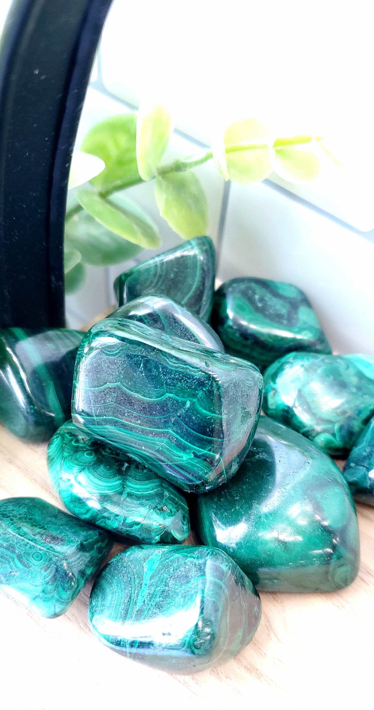 Malachite crystals stones piled up on wooden shelf