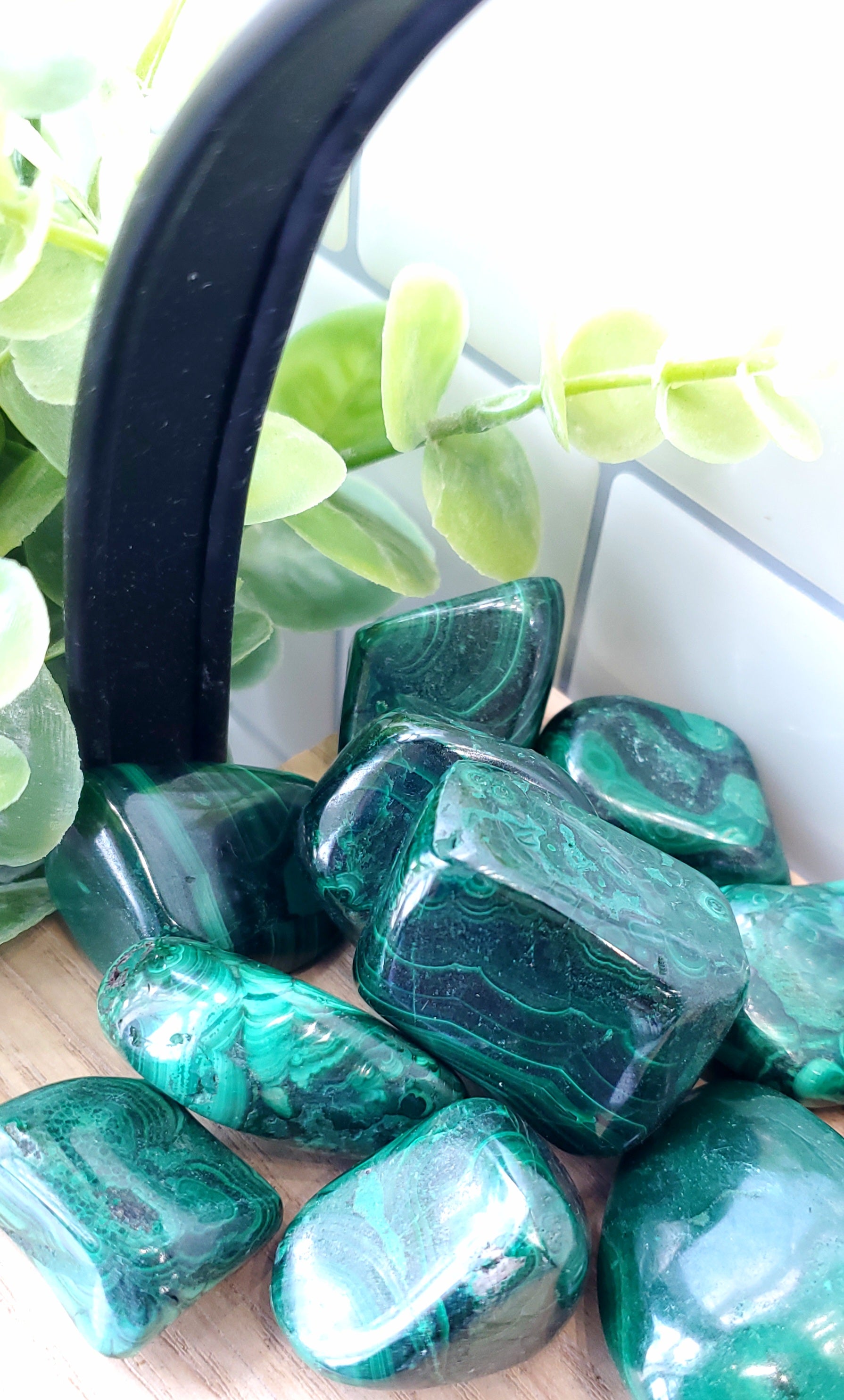 Malachite crystals stones piled up on wooden shelf