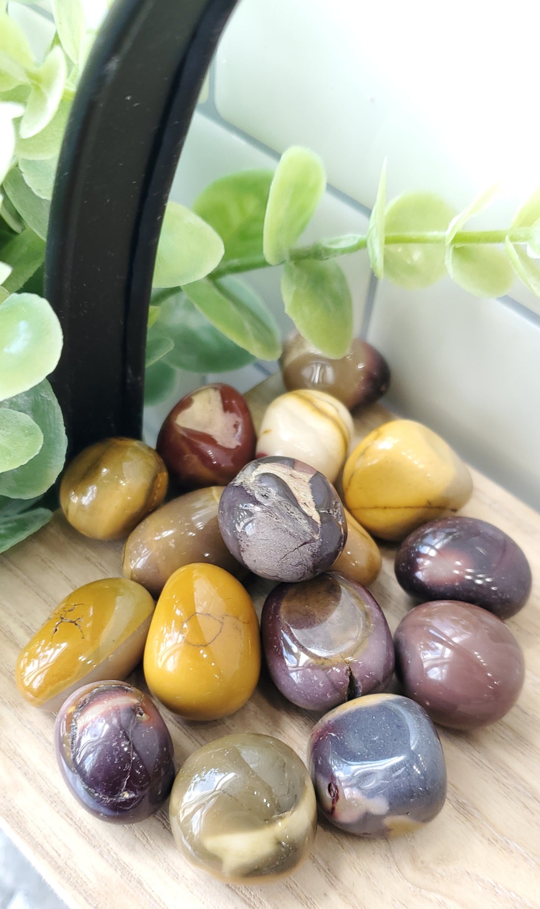 Mookaite crystals stones piled up on wooden shelf