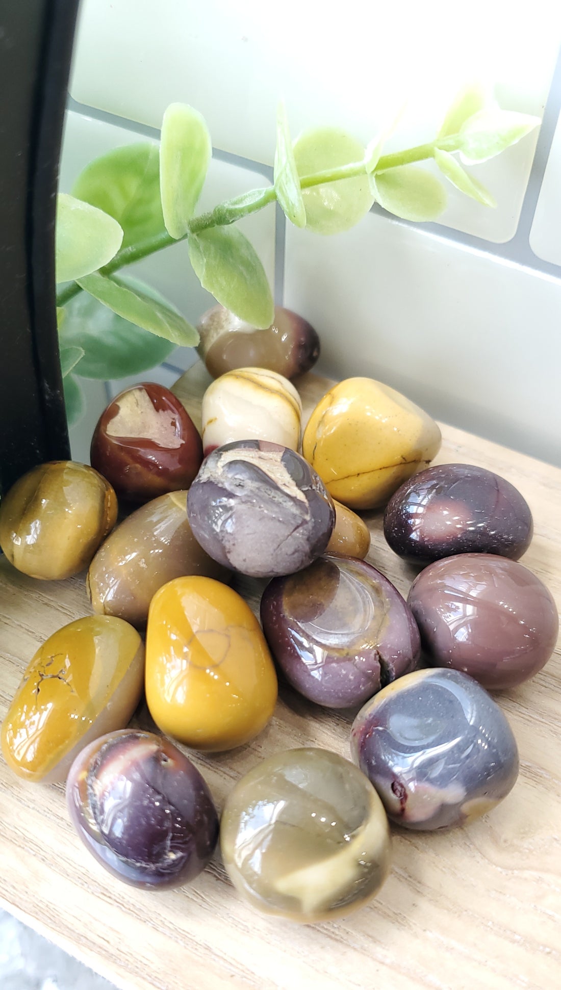 Mookaite crystals stones piled up on wooden shelf