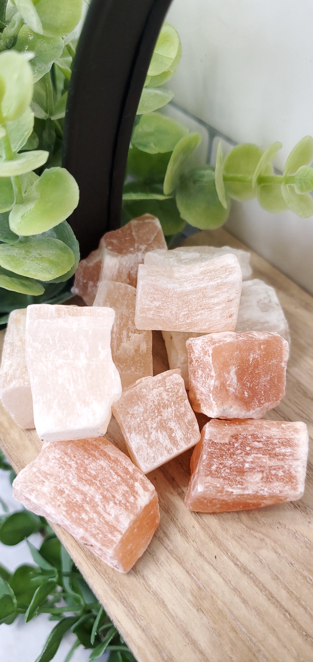 Orange Selenite piled up on a shelf