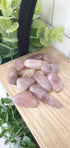Pink Amethyst crystals stones piled on wooden shelf