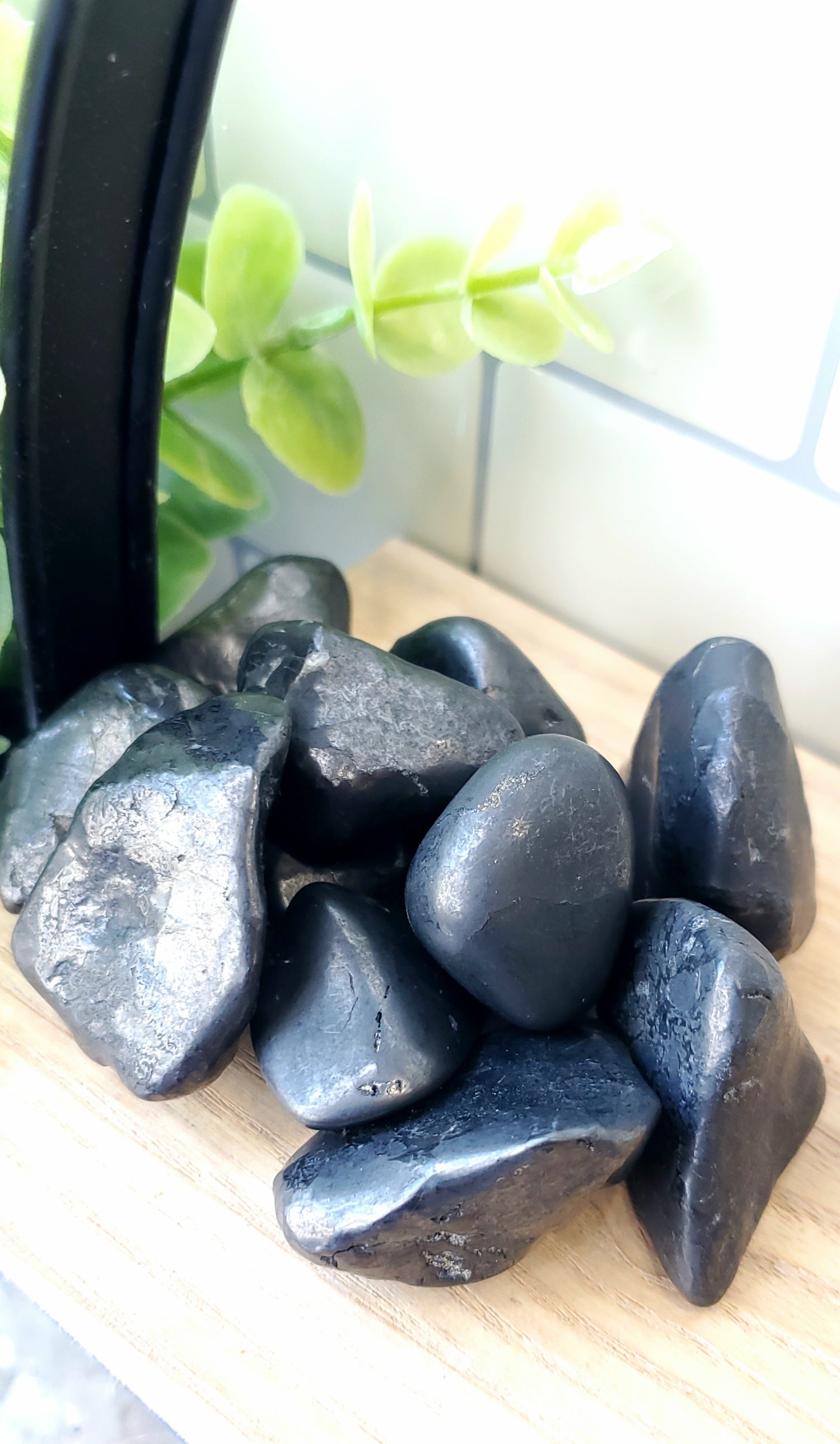 Shungite crystals stones piled on a wooden shelf