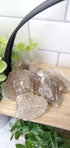 Smokey Quartz crystals stones piled up on wooden shelf